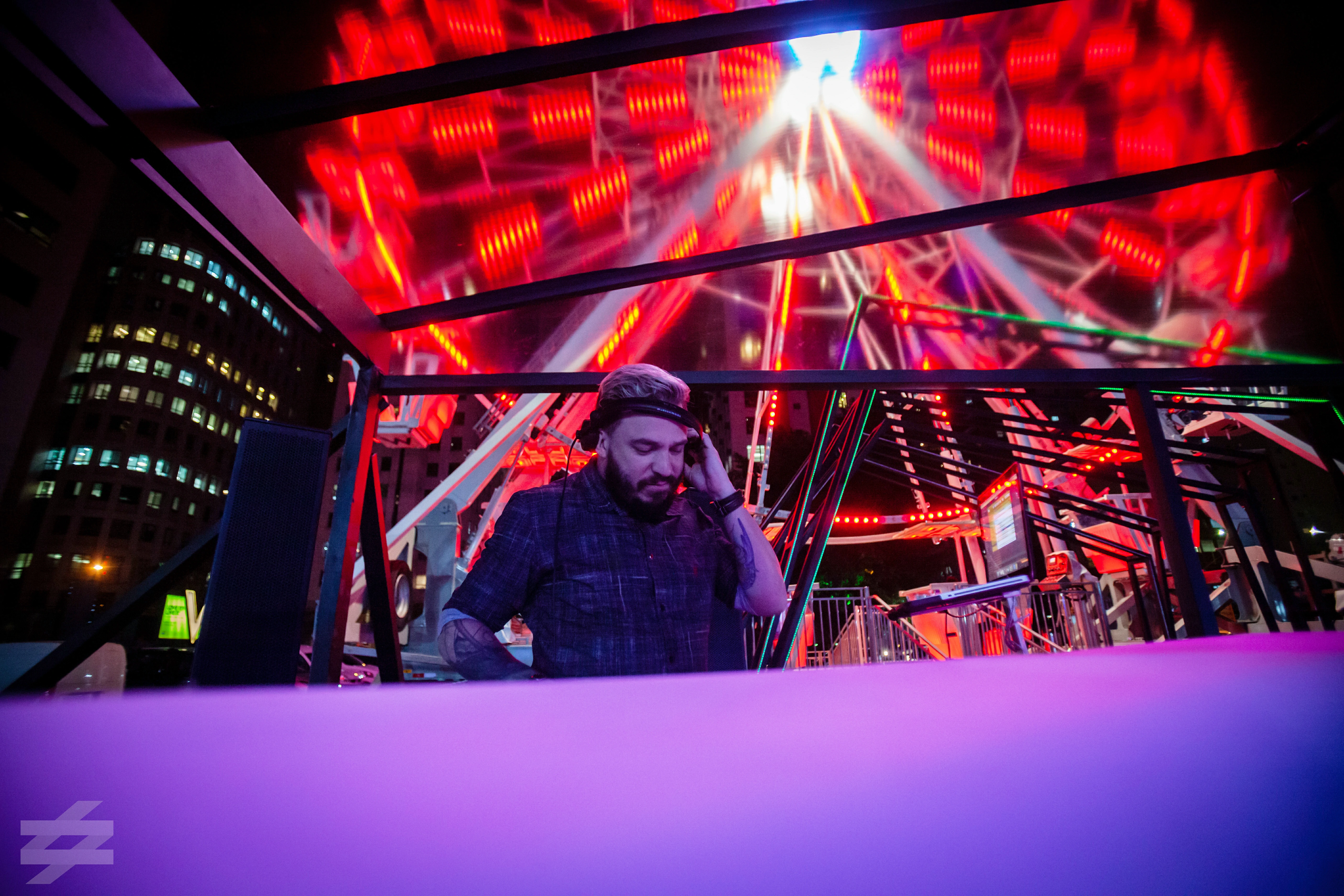 DJ em apresentação noturna com iluminação vermelha no evento Helbor W Residences SP